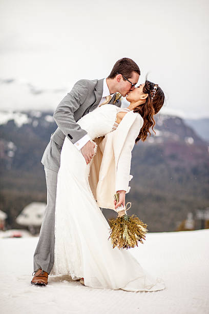 Asian Woman and Caucasian Man Wedding in Snow Mountains A young and attractive Asian woman and caucasian man get married in the mountains with snow from the previous winter still present. chinese wedding dress stock pictures, royalty-free photos & images