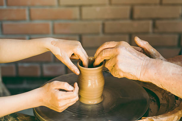 istock Potter teaches to sculpt a clay pot 547429508