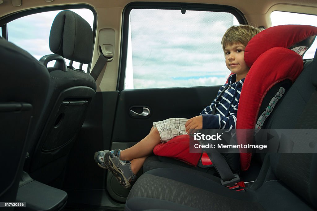 Car seat Little boy sitting in high back booster car seat fasten with seat belt. Child safety. Rocket Booster Stock Photo