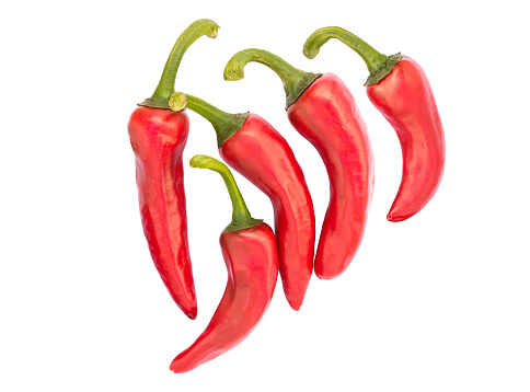 The Espelette pepper (piment d'Espelette) comes from the french town Espelette in the Basque Country, Pyrenees-Atlantiques, France. It is a rather mild chili pepper with an heat level of 2 (from 0 to 10). Five ripe red pods isolated on white background.