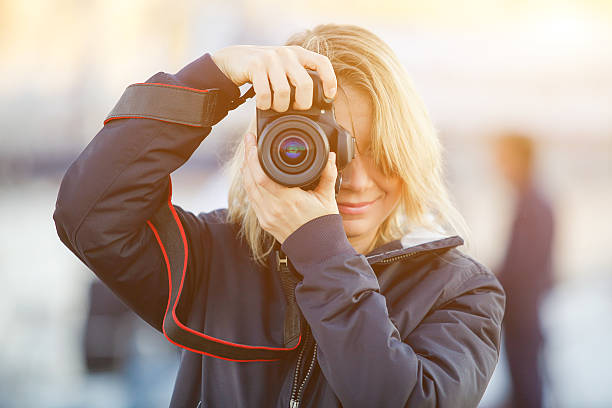 istock Young woman using a camera to take photo outdoor. 547432660