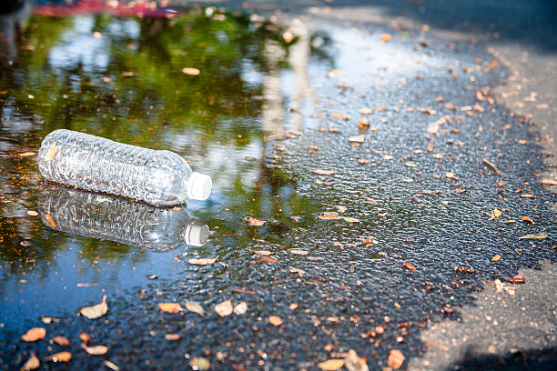istock Pollution.  Empty plastic water bottle discarded on city street. 547433284