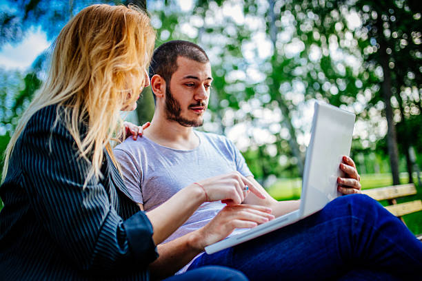 istock Couple on laptop in park 547435108