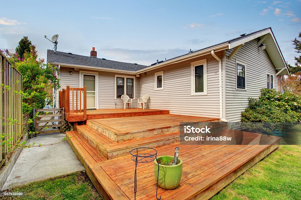 Picture of Large wooden back deck with two chairs. Picture of Large wooden back deck with two chairs. House exterior. Deck Stock Photo
