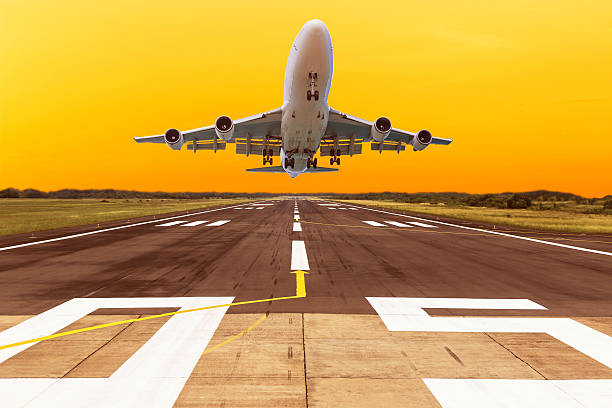 istock airplane flying take off from runway on sunset 547435502