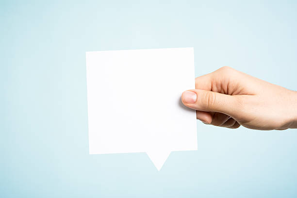 Woman holding white square blank speech bubble, blue background