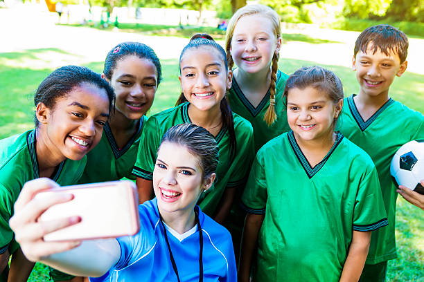 istock Happy soccer coach takes selfie with team 547437956