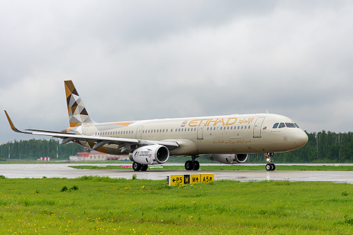 Moscow, Russia - May 19, 2016: Etihad airlines Airbus A321 taxiing. Plane makes taxiing on taxiway Domodedovo International Airport. Rainy and cloudy day.
