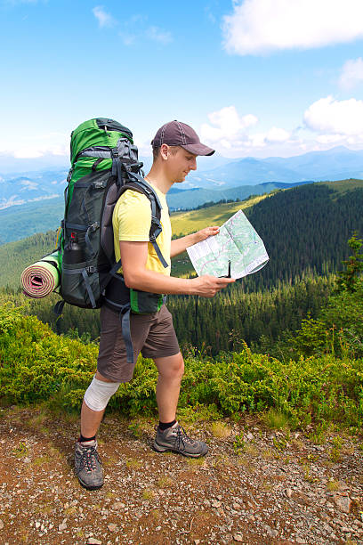 istock Man tourist in mountain read the map 547442458