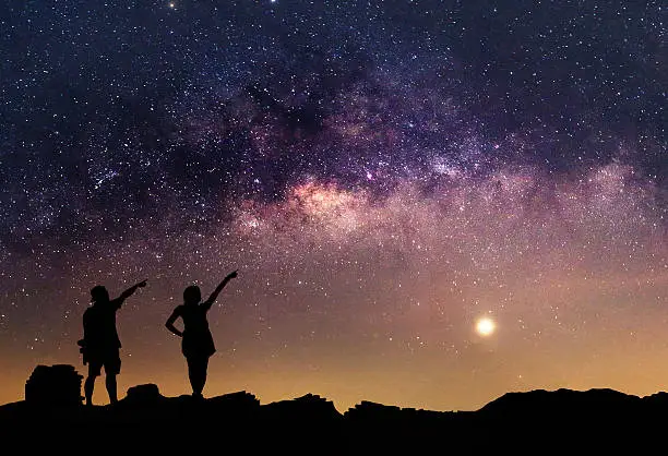 Star-catcher. A person is standing next to the Milky Way galaxy