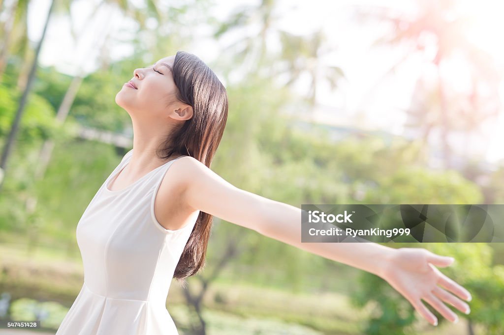 young woman raising her arms young woman raising her arms and smile to you, nature green background Women Stock Photo