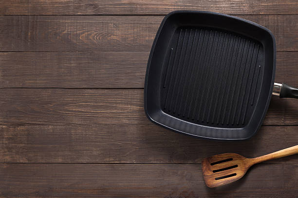 istock Cast iron frying pan and spatula on the wooden background. 547495448