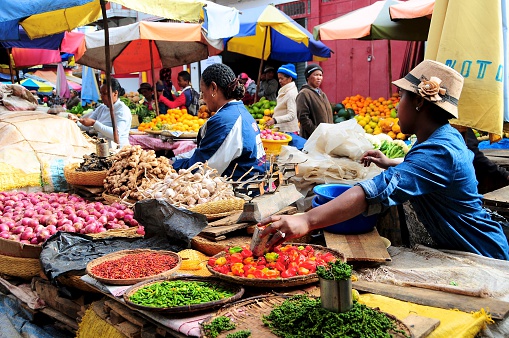 Antananarivo, Madagascar- June 18, 2016:  Vendor selling peppercorns, chillies, shallots, garlic and ginger at Analakely Market.