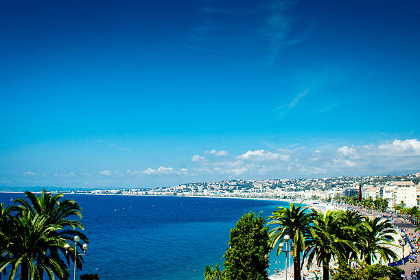 The beach on the Mediterranean sea in Nice, France.  This is on a hot July Sumers day with many holiday makers and tourists on the beach sunbathing.