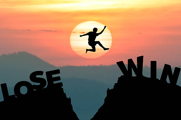 istock Silhouette man jumps get away from LOSE to WIN 547498528