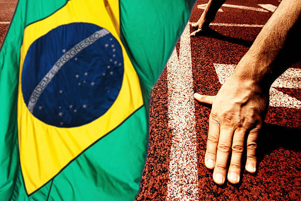 Hands on starting line - running track and Brazil flag