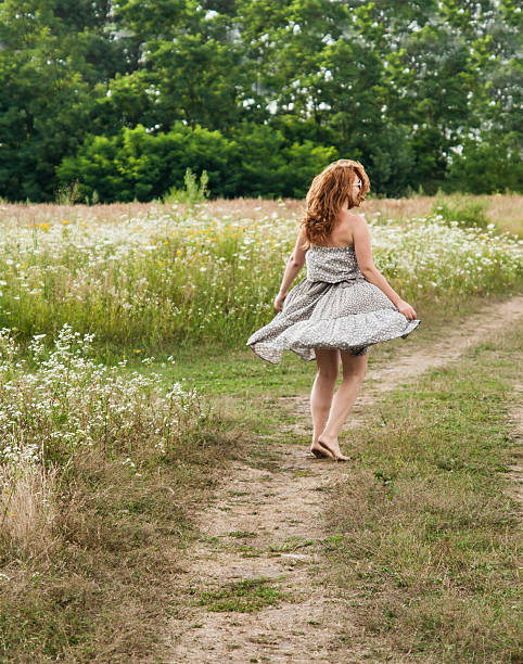istock red-haired young woman spinning in a field 547500376