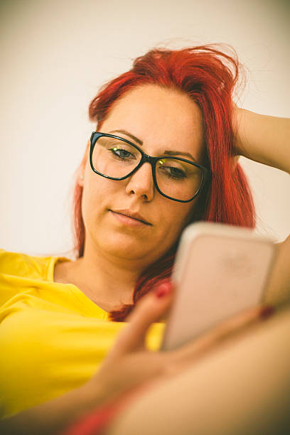 istock Woman sitting on sofa at home, talking on mobile phone 547500982