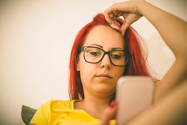 istock Woman sitting on sofa at home, talking on mobile phone 547501084