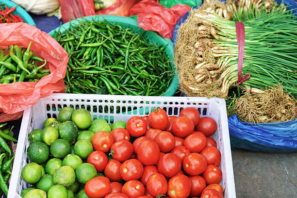 asian street market selling tomato lime pepper and greens - lime market vietnam fruit imagens e fotografias de stock