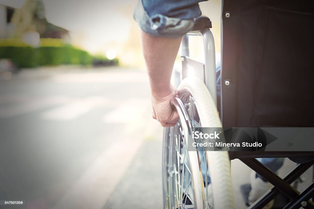 Disabled man on a wheelchair Detail of a disabled man on a wheelchair Paralysis Stock Photo