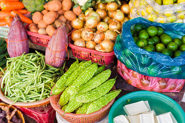 asian street market selling bitter melon lime pea and onion - lime market vietnam fruit imagens e fotografias de stock