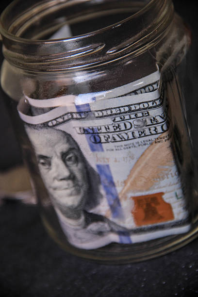 istock Hundred dollar bank note on a glass jar 547505260