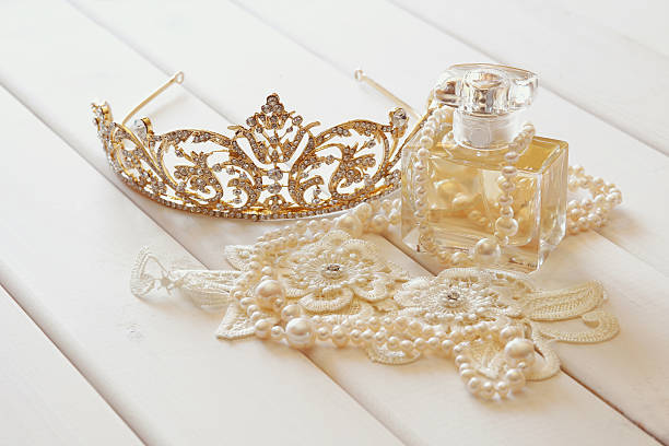 istock White pearls necklace, diamond tiara and perfume bottle 547509308