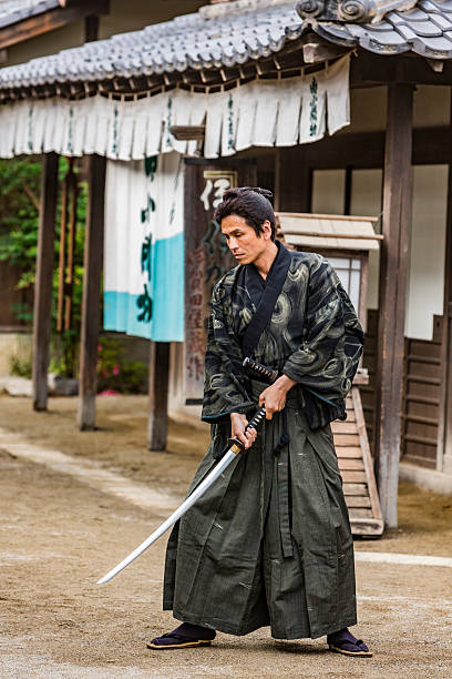 istock Ronin Samurai Warrior With Katana in a Traditional Japanese Village 547510232