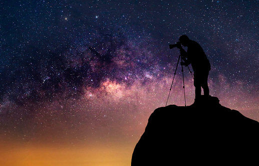 Silhouette of a photographer who shooting a milky way