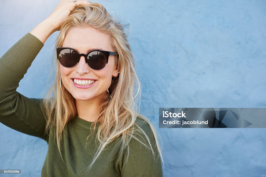 Mujer bonita joven con gafas de sol sonriendo - Foto de stock de Gafas de sol libre de derechos