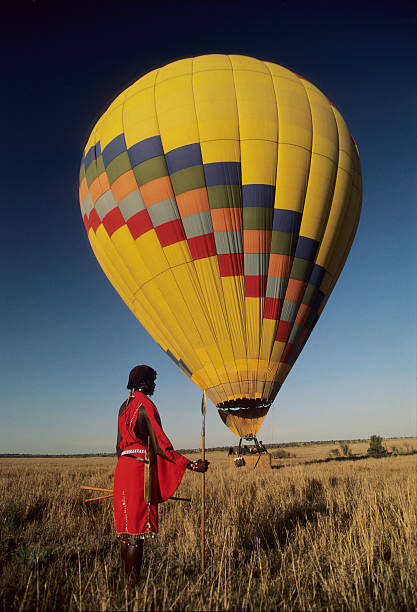 племена масаи наблюдают за взлетаем воздушного шара, масаи мара, кения - национальный заповедник масаи стоковые фото и изображения