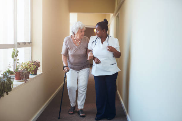 istock Senior woman with walking stick being helped 547513542