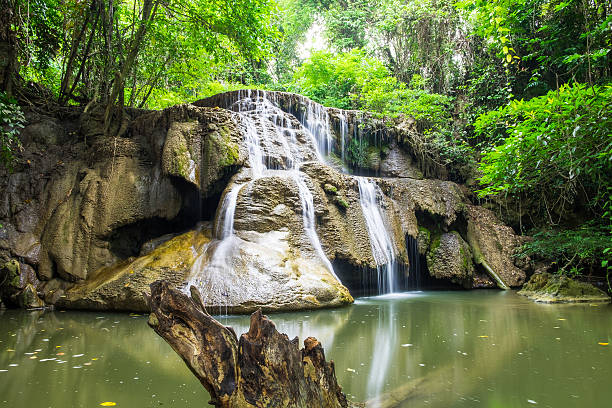 istock Waterfall cliff with log in rainforest at huai mae khamin 547514242