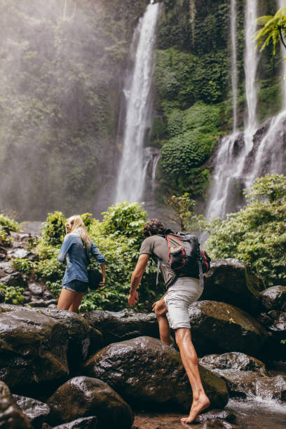 istock Couple crossing a stream together in the forest 547515816