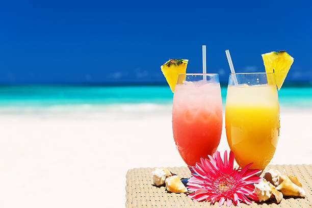 istock Two tropical fresh juices on white sandy beach 547520126