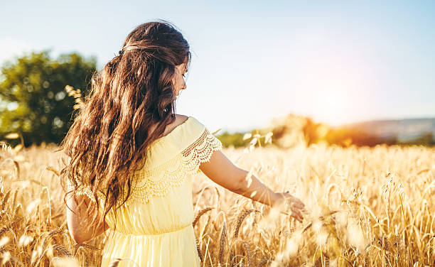 istock beautiful young woman at wheat field 547520716