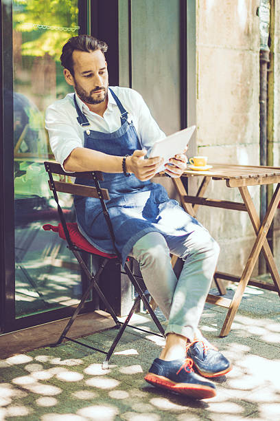 istock Coffee shop owner checking the news 547522854