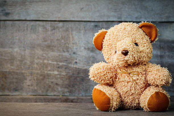 Cute teddy bears sitting on old wood background