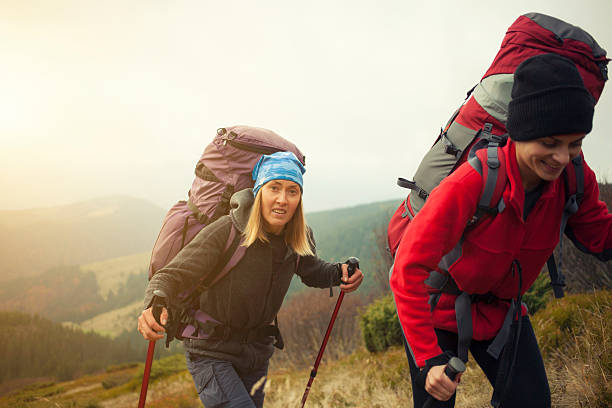 istock Two girls with backpacks coming through the forest. 547524032