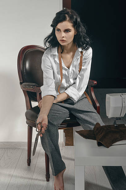 istock Fashion designer sitting with scissors in her hand. 547526664
