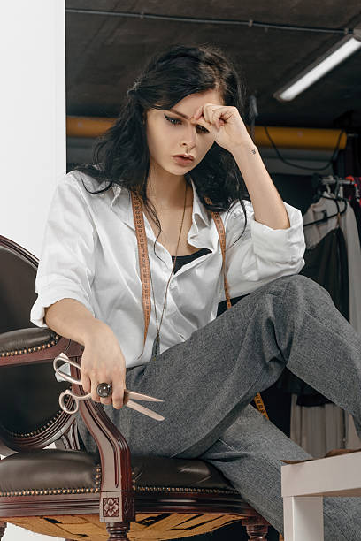 istock Fashion designer sitting with scissors in her hand. 547526824