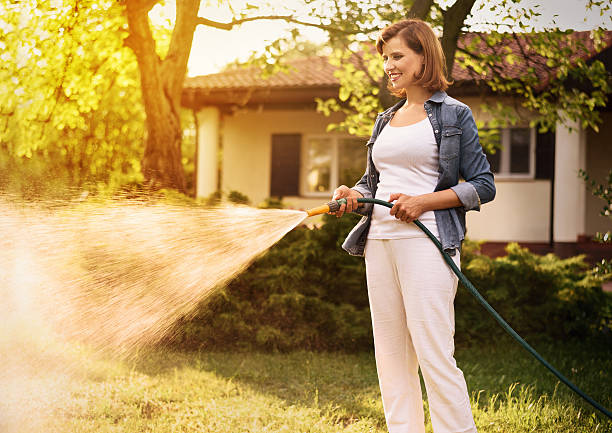 Young woman working in the garden Young woman working in the garden on a summer afternoon. Horizontal image with copy space for text. garden hose photos stock pictures, royalty-free photos & images