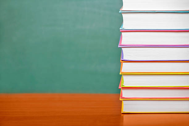 istock Stack of books on a green chalkboard background 547530696