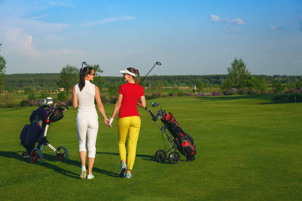 istock Two pretty women golfers walking at golf course 547531606