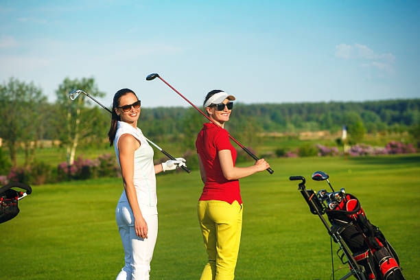 istock Two pretty women golfers walking at golf course 547531632