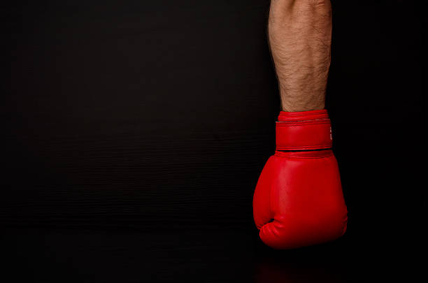 istock Man hand in red boxing glove, black background 547531908