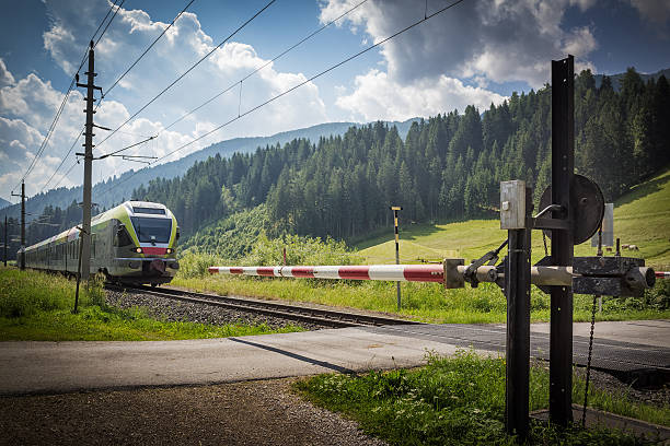 Rail crossing A train reaches a rail crossing in Lienz, Austria trentino south tyrol stock pictures, royalty-free photos & images