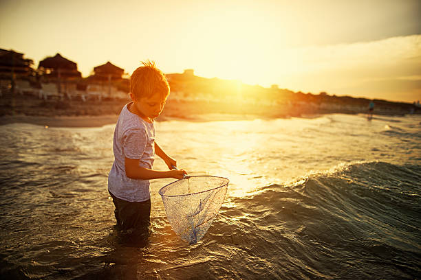 Itacare, Bahia, Brazil - November 30, 2019: A fisherman is seen throwing a fishing net during sunset on the seashore in the city of Itacare, Bahia.