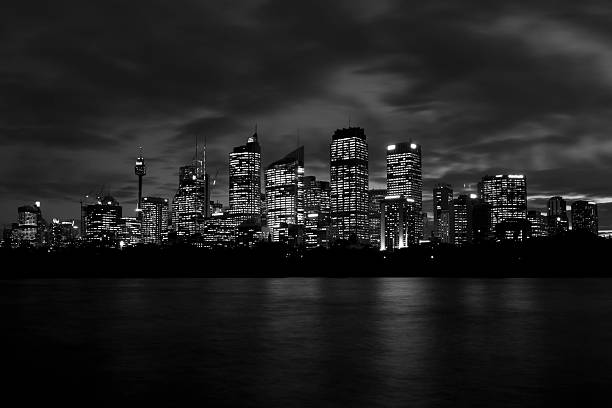 Sydney Skyline Skyscrapers mirroring in the tranquil water at dusk. Panoramic view towards of the Sydney Downtown Skyline Skyscrapers, Tower and Office Buildings. Scenic Twilight Sydney Panorama, Motion Blurred Twilight Clouds. Long Time Exposure. Sydney, Australia.
